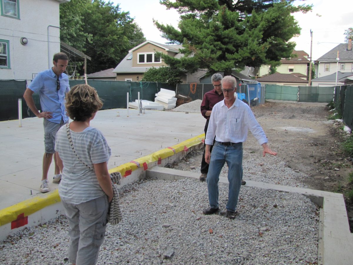 Tom stands in the future enclosed porch of the Right Sized Passive House in 2013. The enclosed porch creatively allowed Passive Houses to have private, cozy fireplaces while maintaining pristine indoor air quality.